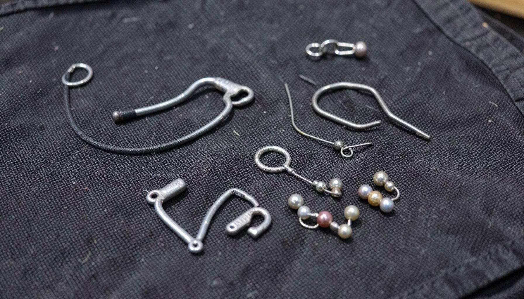 Helicopter rig components laid out on a dark tackle mat: hooklink, swivel, beads, and lead
